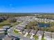 Wide aerial shot of a new home community featuring scenic water views and lush greenery at 5315 Meadow Song Dr, Okahumpka, FL 34762