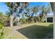 An expansive backyard offers serene views with mature trees and easy access to the community pond at 5315 Meadow Song Dr, Okahumpka, FL 34762