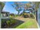 A serene backyard featuring mature trees, lush greenery, and a glimpse of the screened lanai at 5315 Meadow Song Dr, Okahumpka, FL 34762