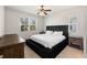 Bright bedroom featuring a large window, ceiling fan, and upholstered bed at 5315 Meadow Song Dr, Okahumpka, FL 34762