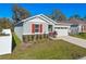 Charming single-Gathering home features a two-car garage, colorful window shutters and inviting landscaping at 5315 Meadow Song Dr, Okahumpka, FL 34762