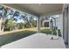 Covered patio area showcasing a punching bag and serene views of the backyard at 5315 Meadow Song Dr, Okahumpka, FL 34762