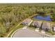 Overhead view of a modern home with a lush lawn and beautiful pond view, backing to wooded area at 5376 Dagenham Dr, Davenport, FL 33837