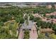 Aerial view of a gated community with a grand entrance, surrounded by trees and lakes at 5376 Dagenham Dr, Davenport, FL 33837