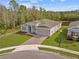 Aerial view of a modern home featuring pristine landscaping and a brick driveway in a serene neighborhood at 5376 Dagenham Dr, Davenport, FL 33837