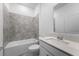 Bathroom featuring a tub with gray tile and a sink with modern fixtures at 5376 Dagenham Dr, Davenport, FL 33837