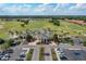 Stunning aerial view of the clubhouse and golf course, showcasing the beautifully landscaped grounds and parking area at 5376 Dagenham Dr, Davenport, FL 33837