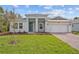 Charming single-story home featuring a well-manicured lawn, brick driveway and a welcoming entrance at 5376 Dagenham Dr, Davenport, FL 33837