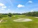 Beautiful view of a lush green golf course featuring mature trees and meticulously maintained green at 5376 Dagenham Dr, Davenport, FL 33837