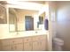 Bathroom with double sink vanity, large mirror, tile flooring, and a separate toilet at 6065 Dory Way, Tavares, FL 32778