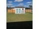 Large backyard featuring a shed with white trim and blue door at 719 Del Ray Dr, Kissimmee, FL 34758