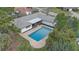 An aerial view of the property featuring a swimming pool, a screened lanai, and a well-manicured lawn at 7531 Lodge Pole Trl, Winter Park, FL 32792