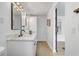 Bright bathroom with dual vanity, marble countertop, modern lighting, and wood-look flooring at 7531 Lodge Pole Trl, Winter Park, FL 32792