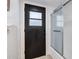 Close-up of a dark-colored door and glass shower in a bathroom with white tiling at 7531 Lodge Pole Trl, Winter Park, FL 32792