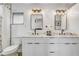 A bathroom with dual sinks, white cabinets, and modern lighting fixtures above the mirrors at 7531 Lodge Pole Trl, Winter Park, FL 32792