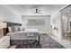 Bedroom featuring a grey tufted headboard, ceiling fan, light-colored wood floors and an ensuite bathroom at 7531 Lodge Pole Trl, Winter Park, FL 32792