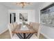 Contemporary dining area featuring a rustic wood table, upholstered chairs, and a unique light fixture at 7531 Lodge Pole Trl, Winter Park, FL 32792