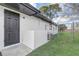 Exterior side entrance to house with black door and white walls at 7531 Lodge Pole Trl, Winter Park, FL 32792