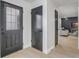 Entryway with black doors and luxury vinyl plank flooring leading into the living area at 7531 Lodge Pole Trl, Winter Park, FL 32792