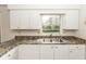 Well-lit kitchen showcases stainless steel sink, neutral countertops and bright white cabinets at 759 Swallow St, Deltona, FL 32725