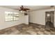 Bright living room with checkered tile floors, fan, staircase and ample natural light from a large window at 759 Swallow St, Deltona, FL 32725