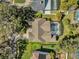 An aerial view shows a home with a screened pool, mature trees and adjacent well-maintained landscaping at 7609 Sandstone Dr, Orlando, FL 32836