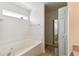 Bathroom soaking tub featuring tile surround, window, and views into the primary bedroom at 939 Van Loon Ct, Kissimmee, FL 34758