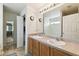 Well-lit bathroom featuring double sinks, wood cabinets, tile flooring, and a large mirror at 939 Van Loon Ct, Kissimmee, FL 34758