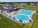 An aerial view of a community pool area featuring a water area, seating, and lounge chairs with umbrellas at 939 Van Loon Ct, Kissimmee, FL 34758