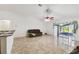 A spacious living room featuring tile floors and a sliding glass door to the sunroom at 939 Van Loon Ct, Kissimmee, FL 34758