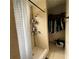 This is a shower area next to a closet with a shower head, curtain, and storage shelves at 2600 Elm Ave, Sanford, FL 32773