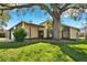 Inviting single-story home featuring a covered porch, mature shade trees, and a well-maintained lawn at 10 Trophy Ln, Kissimmee, FL 34759