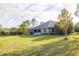 This home features a spacious backyard with lush green grass and a screened in porch at 1045 S State Road 415, New Smyrna Beach, FL 32168