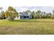 Spacious backyard with lush green grass and mature trees at 1045 S State Road 415, New Smyrna Beach, FL 32168