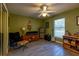 The bedroom features green walls, a ceiling fan, wood-look tile flooring and a window with plenty of natural light at 1045 S State Road 415, New Smyrna Beach, FL 32168