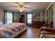 Comfortable bedroom features wood flooring, ceiling fan, natural lighting, and decor at 1045 S State Road 415, New Smyrna Beach, FL 32168