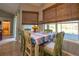 Bright breakfast nook features natural lighting, decorative wooden chairs and a view of the pool at 1045 S State Road 415, New Smyrna Beach, FL 32168
