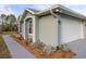 Home exterior displaying architectural detail, garden beds, and a paved walkway at 1045 S State Road 415, New Smyrna Beach, FL 32168
