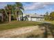 Inviting home exterior showcasing a well-manicured lawn and mature palm trees at 1045 S State Road 415, New Smyrna Beach, FL 32168