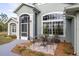 Charming home exterior with large windows, screened entrance and outside seating at 1045 S State Road 415, New Smyrna Beach, FL 32168