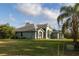 Home exterior featuring lush green grass and mature trees at 1045 S State Road 415, New Smyrna Beach, FL 32168