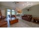Spacious living room has open floor plan, ceiling fans, and sliding door to the patio at 1045 S State Road 415, New Smyrna Beach, FL 32168