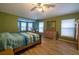 Green main bedroom showcasing wood-look tile flooring, a bay window sitting area, and a dresser with a mirror at 1045 S State Road 415, New Smyrna Beach, FL 32168