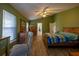 Spacious main bedroom features green walls, vaulted ceiling, wood-look tile flooring, and a large window with natural light at 1045 S State Road 415, New Smyrna Beach, FL 32168