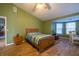 A well-lit main bedroom features green walls, wood-look tile floors, and a bay window seating area at 1045 S State Road 415, New Smyrna Beach, FL 32168