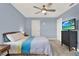 Bedroom with a comfortable bed, TV, ceiling fan, and neutral-colored carpet at 12144 Philosophy Way, Orlando, FL 32832