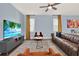 Spacious living room featuring a plush brown leather couch and entertainment center with a large flatscreen TV at 12144 Philosophy Way, Orlando, FL 32832