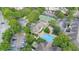 Aerial view of a community featuring a pool, tennis court and mature landscaping at 13013 Mulberry Park Dr # 222, Orlando, FL 32821
