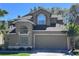 Charming home featuring a two-car garage, arched windows, and well-maintained landscaping at 14218 Squirrel Run, Orlando, FL 32828