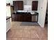 A kitchen sink featuring stainless steel appliances and dark cabinets, complemented by tile flooring at 14218 Squirrel Run, Orlando, FL 32828